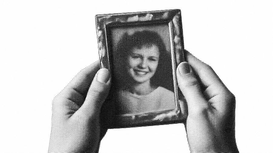 古い写真を両手で掲げ持つ様子